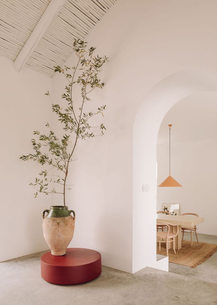 An arch doorway leading to a dining area with wooden furniture