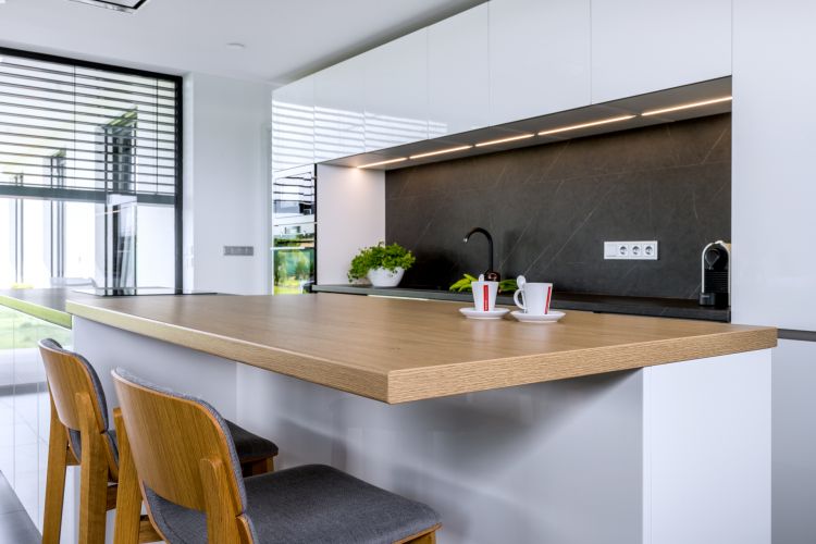 A kitchen with a sleek, contemporary design and natural furniture accents