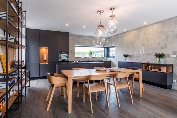 A modern kitchen with sleek design and Merano chair and armchair