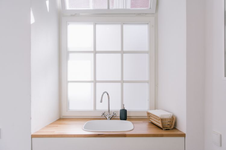A minimalist sink next to a large window