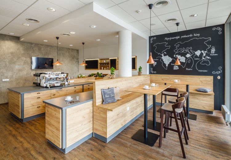 A stylish coffee shop interior featuring a prominent espresso machine on a wooden counter with gray accents
