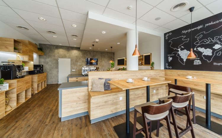 A modern coffee shop interior showcasing wooden counters and shelves with various coffee machines and equipment.