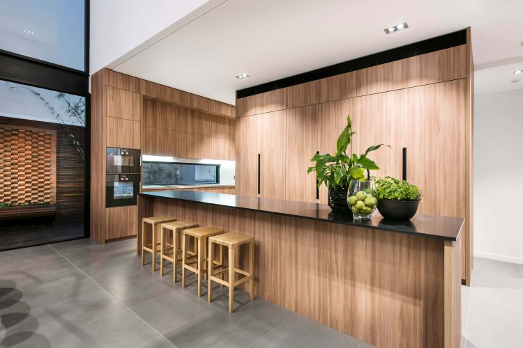 Modern kitchen interior with sleek wooden cabinetry and a built-in oven.