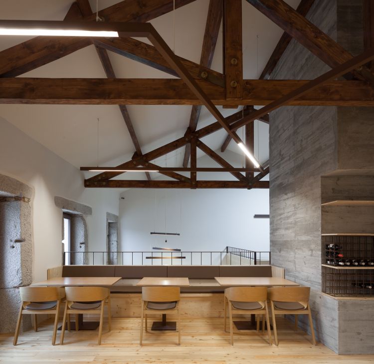 Modern dining area with wooden beams on the ceiling and sleek linear lighting fixtures.