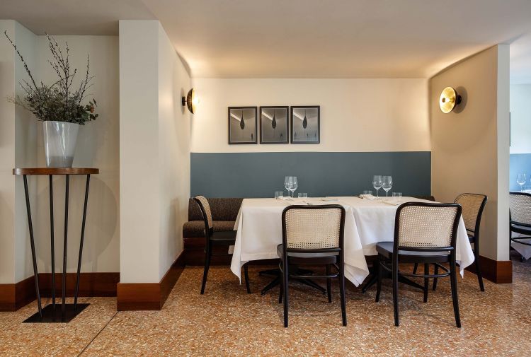 Contemporary black chairs with perforated backrests are paired with the tables.