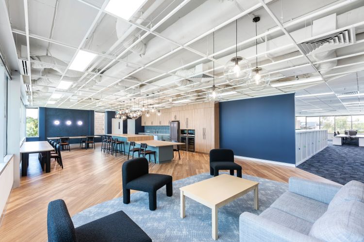Spacious open-concept office with industrial-style exposed white ceiling beams and ductwork.