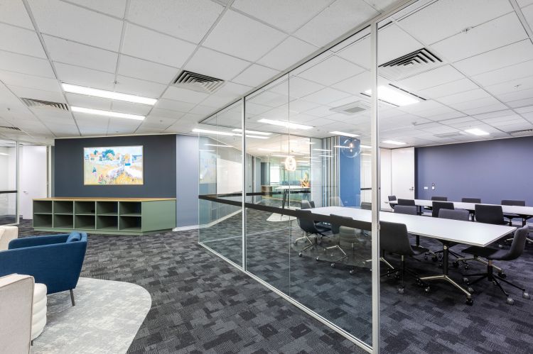 Spacious office area featuring a combination of open spaces and glass-partitioned rooms.