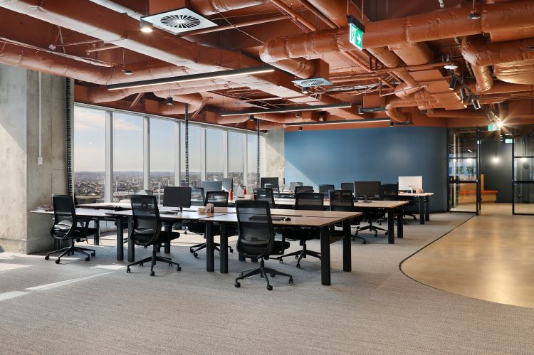 Modern open-plan office space with large windows offering a cityscape view.