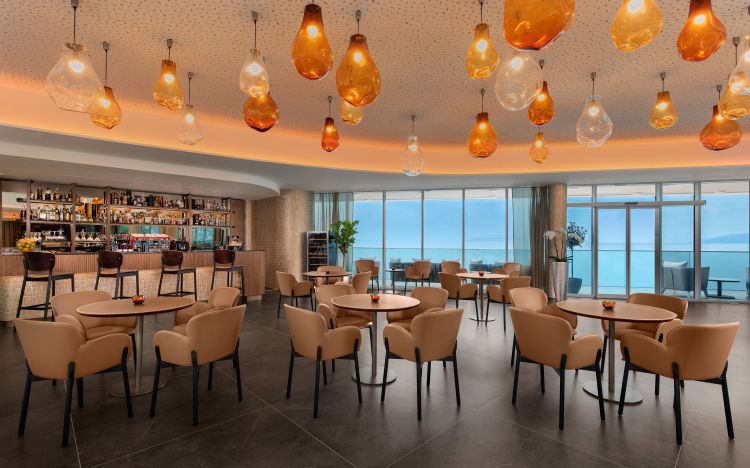 Elegant lounge area featuring a well-stocked bar, amber-hued pendant lights hanging from the ceiling