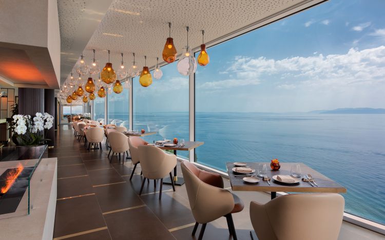 Chic dining area with floor-to-ceiling windows offering a panoramic ocean view