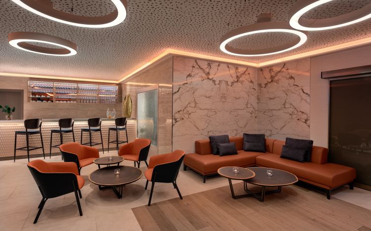 Elegant lounge area with circular overhead lights, a marble accent wall