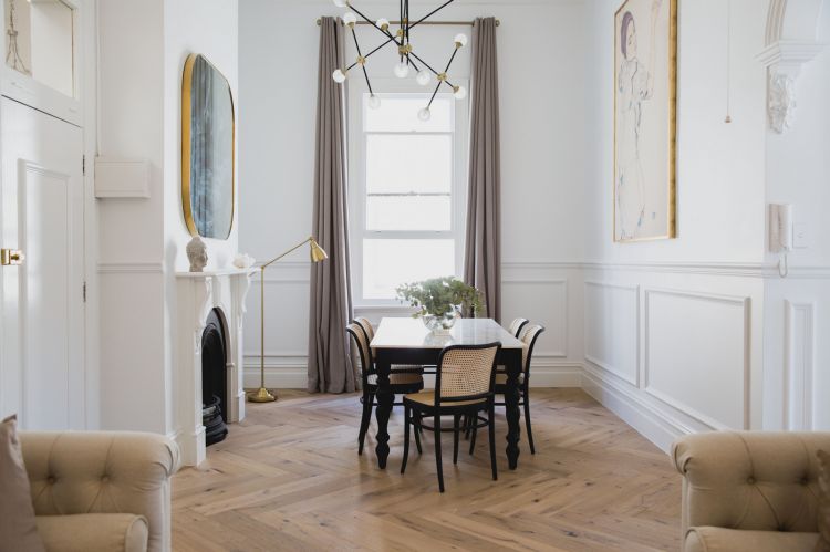 A refined dining space featuring a contemporary gold chandelier with multiple arms and spherical bulbs