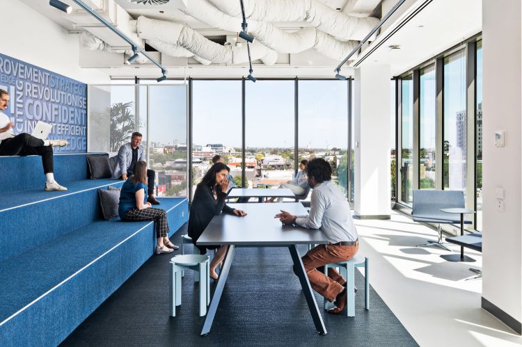 Modern office lounge with floor-to-ceiling windows providing a clear view of the city