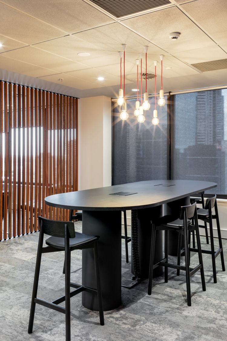 A stylish and modern meeting room featuring a unique oval table surrounded by Andi stools