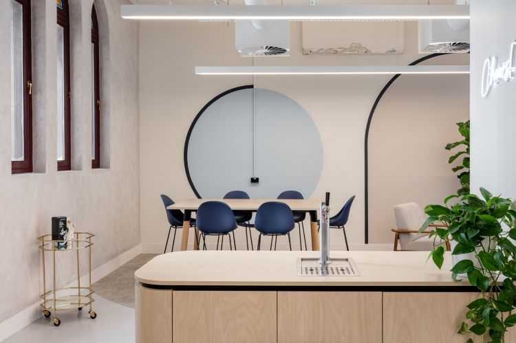 A stylish office space featuring a wooden reception desk with a built-in tap