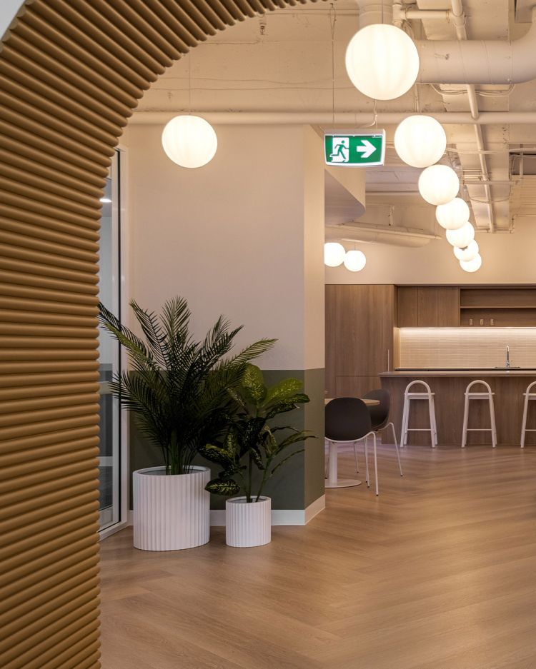 A view through a corrugated archway into a modern office space. 