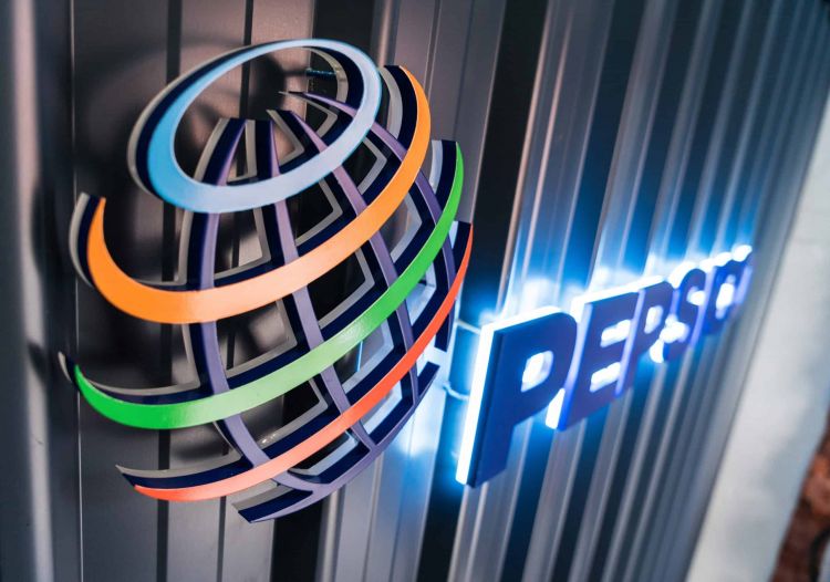  Illuminated PepsiCo logo with colorful rings on a striped metal background.