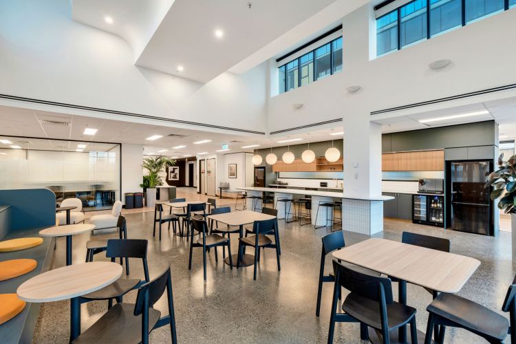 cozy booths to communal tables, illuminated by large globe pendant lights, with a kitchen area in the background.