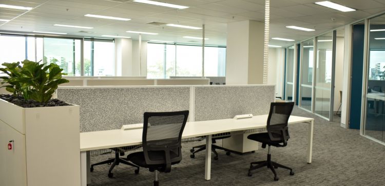 Modern office space with cubicles featuring white desks, black office chairs