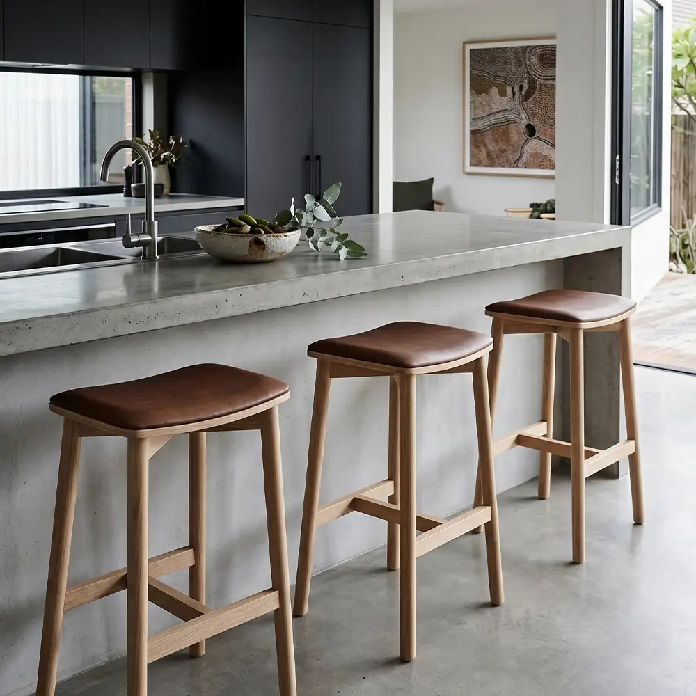 Tan leather kitchen stools in a modern home with marble bench