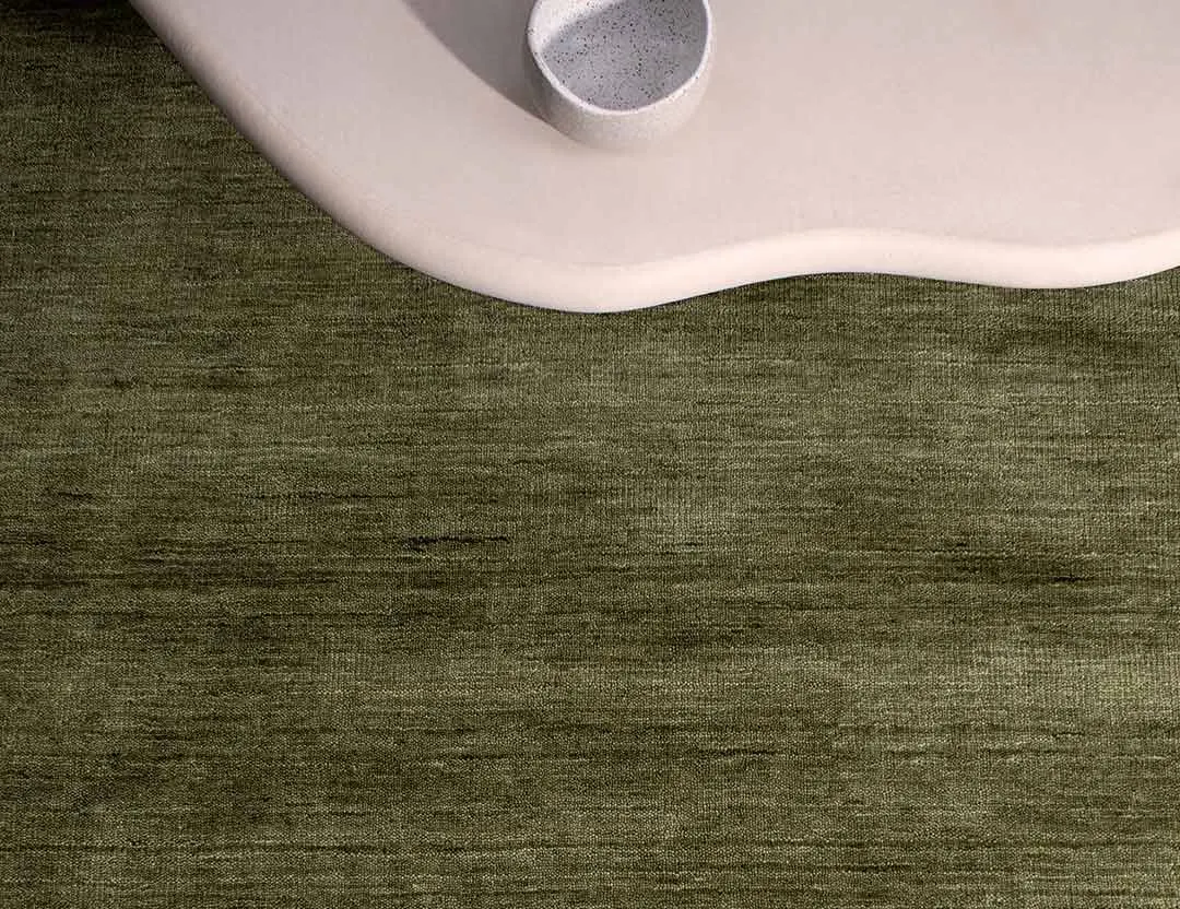 Diva Fringed Wool Rug in fern green with blush pink curved coffee table