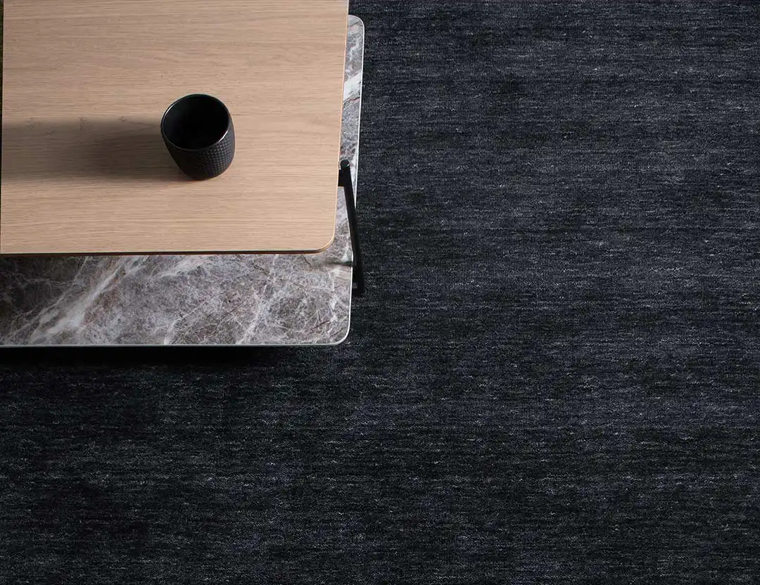 Diva Fringed Wool Rug in cinder black with grey marble and timber coffee table