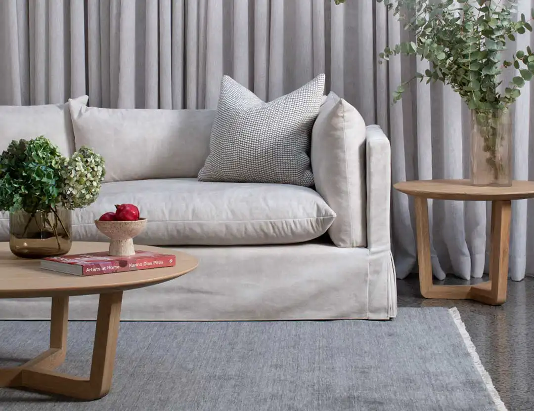 Diva Fringed Wool Rug in Shadow grey with rounded wooden coffee table and beige lounge