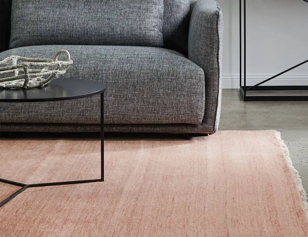 Diva Fringed Wool Runner in Rosetta pink with black marble coffee table and charcoal sofa