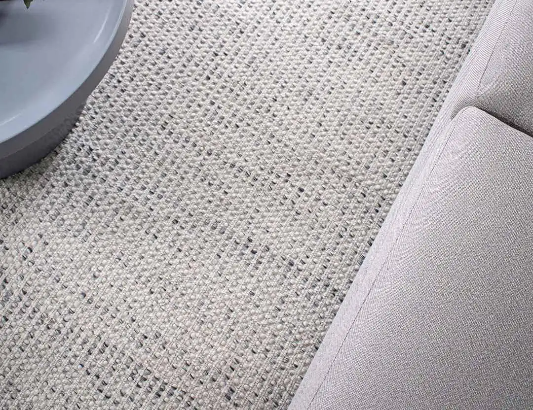 Kobe Wool Rug in Fog grey flecked with charcoal, set with grey sofa and soft blue side table