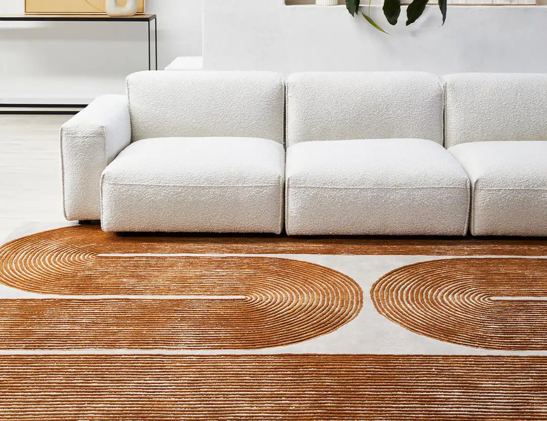 Viper Wool Patterned Rug in golden geometric swirls with a beige sofa