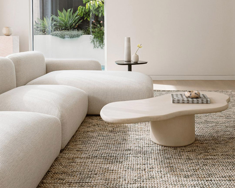 green and beige textured wool rug in a loungeroom with beige couch and coffee table