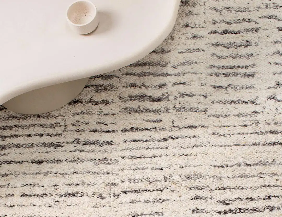Kasbah Boho Wool Rug in Ivory & Silver with curvy beige coffee table